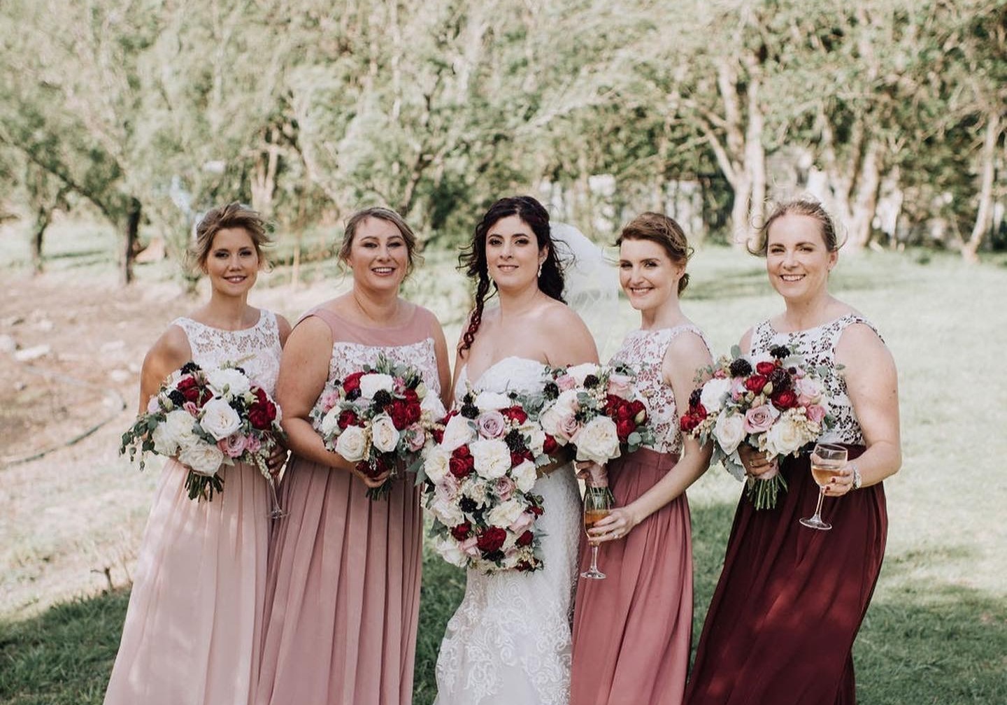 Bridal party in rose and burgundy bridesmaid dresses altered on the NSW South Coast