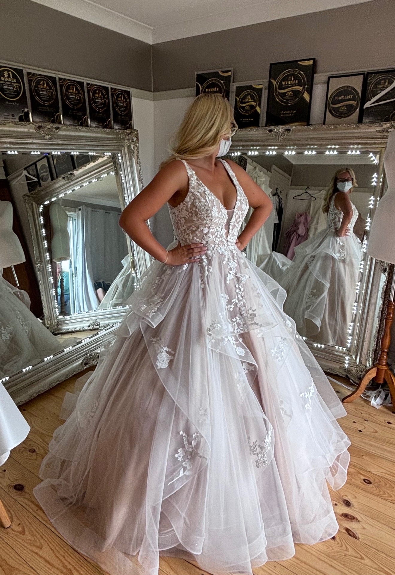 Bride in a blush layered tulle ball gown with floral appliqué bodice and cascading skirt — ball gown resizing, hemming and bustling by Jacqui
