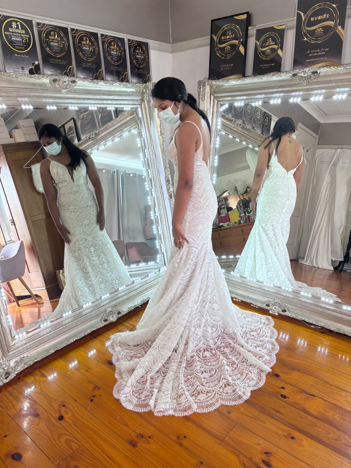 Bride in profile wearing a fitted ivory lace mermaid gown with dramatic scalloped fan train — scalloped train hemming and bustle alterations by Jacqui